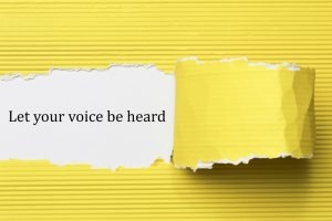 Let your voice be heard written under torn paper